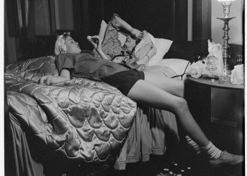 Two teenagers relax on a bed at the end of the day. They were part of a photo essay published in McCall's Magazine depicting the day in the life of an American teenager. (Photo by Reznikoff Artistic Partnership/Corbis via Getty Images)