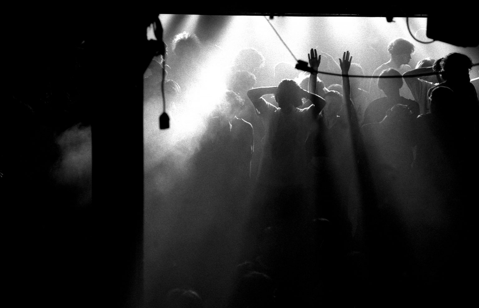 A clubber raises their hands on an atmospheric main stage during a break in the music at the Hacienda, Manchester 1988. (Photo by Peter J Walsh/Peter J Walsh/PYMCA/Avalon/Getty Images)