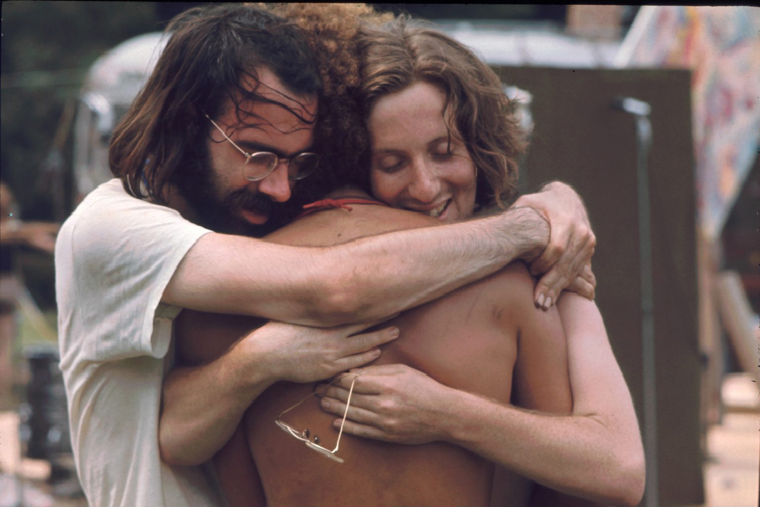 Three men attending the Woodstock music festival hug each other, Bethel, NY, August 1969. (Photo by Ralph Ackerman/Getty Images)